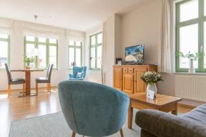 a living room with a couch and a table and chairs at Villa Frohsinn App 15 in Bansin