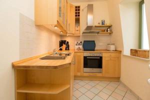 a kitchen with wooden cabinets and a sink at Villa Frohsinn App 15 in Bansin +10 photos