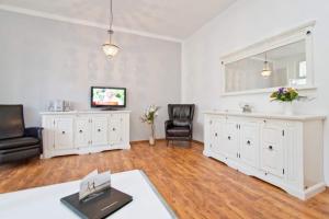 sala de estar con muebles blancos y TV en Villa Hartmann Drewitz, App 06, en Heringsdorf