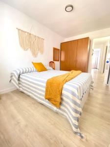 a bedroom with a large bed with a striped blanket at Apartamento en playa de Altafulla in Altafulla