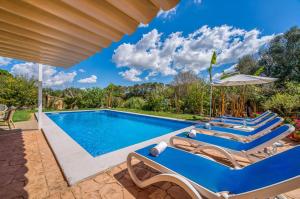 a swimming pool with lounge chairs and an umbrella at Ideal Property Mallorca - Can Tomeu in Llubí