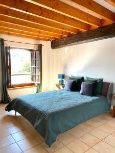 a bedroom with a bed with a blue comforter and a window at Domaine du Cellier de la Couronne in Sézanne