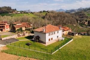 eine Luftansicht eines großen weißen Hauses auf einem Hügel in der Unterkunft Apartamentos La Cortina in Cangas de Onís