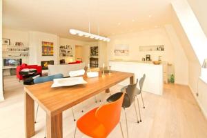 uma cozinha e sala de jantar com uma mesa de madeira e cadeiras em Villa Hintze App 13 em Heringsdorf