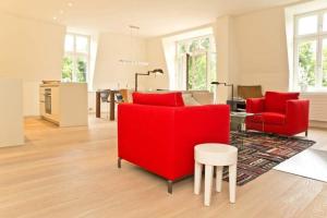 uma sala de estar com cadeiras vermelhas e uma mesa em Villa Hintze App 13 em Heringsdorf