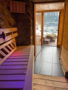 a room with a wooden bed and a large window at Heidi Chalet in Rossinière