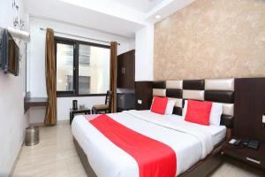 a bedroom with a large bed with red pillows at Hotel Winner Inn in Amritsar