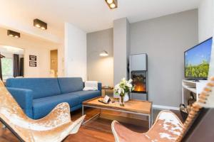 ein Wohnzimmer mit einem blauen Sofa und Stühlen in der Unterkunft Villa Limora, App. 04 in Heringsdorf