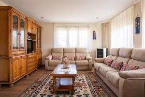 ein Wohnzimmer mit einem Sofa und einem Couchtisch in der Unterkunft Apartamentos La Cortina in Cangas de Onís