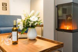 eine Flasche Wein und eine Vase Blumen auf dem Tisch in der Unterkunft Villa Limora, App. 04 in Heringsdorf
