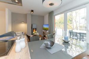 ein Esszimmer und ein Wohnzimmer mit einem Glastisch in der Unterkunft Villa Limora, App. 04 in Heringsdorf