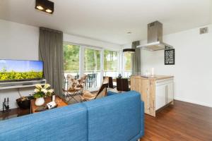 ein Wohnzimmer mit einer blauen Couch und einer Küche in der Unterkunft Villa Limora, App. 04 in Heringsdorf