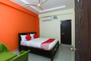 a bedroom with a bed with an orange wall at Flagship S V Residency in Lingampalli