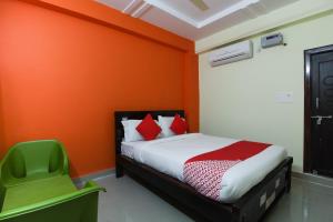 a bedroom with a bed and a green chair at Flagship S V Residency in Lingampalli