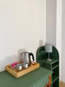 uma chaleira de chá numa bandeja de madeira sobre uma mesa em Domaine du Cellier de la Couronne em Sézanne