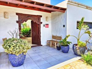 a porch with potted plants and a wooden door at No 23, Bali House in Lajares