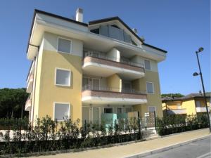 um edifício amarelo no lado de uma rua em Charming sea front view apartment-Beahost Rentals em Rosolina Mare