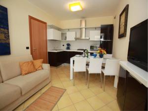 uma sala de estar com um sofá e uma mesa com cadeiras em Charming sea front view apartment-Beahost Rentals em Rosolina Mare
