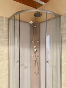 a shower with a glass door in a bathroom at Domaine du Cellier de la Couronne in Sézanne