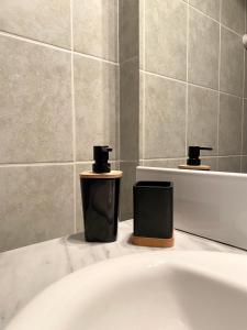 La salle de bains est pourvue d'une baignoire et de 2 distributeurs de savon. dans l'établissement Domaine du Cellier de la Couronne, à Sézanne