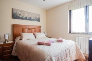 A bed or beds in a room at Apartamentos La Cortina