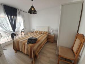 ein Schlafzimmer mit einem Bett, einem Stuhl und einem Fenster in der Unterkunft Amadeu 1, Calella in Calella