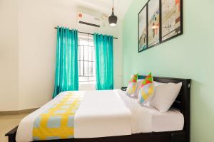 1 dormitorio con 1 cama con cortinas azules en OYO Home KC Arcade en Kochi