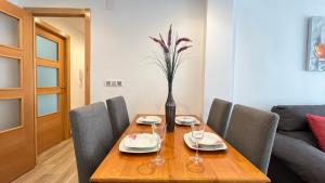 a wooden table with chairs and a vase with flowers at Palmar - 3 Habitaciones, cerca del Hospital Arrixaca in Murcia +16 photos