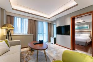 Sala de estar con cama, sofá y mesa en Holiday Inn Suites Xi'an High-Tech Zone, an IHG Hotel en Xi'an