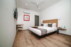a hotel room with a large bed and a desk at OYO Townhouse 067 Chattarpur Opp. Tivoli Garden Near Chhatarpur Metro Station in New Delhi