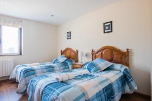 A bed or beds in a room at Apartamentos La Cortina