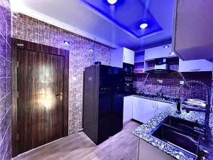 a kitchen with a sink and a black refrigerator at The Moonshine Residence-Royal in Nnewi