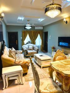 sala de estar con sofás, mesa y sofá en The Moonshine Residence-Royal, en Nnewi