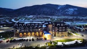 a large building with a parking lot in front of it at Hotel Club Bucovina Resort & Spa in Gura Humorului