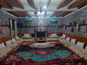 a living room with a large rug on the floor at Guest House Korabi in Ceren