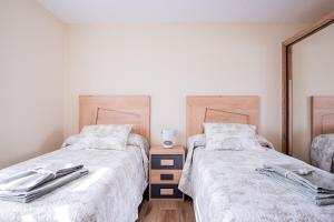 A bed or beds in a room at Apartamentos La Cortina