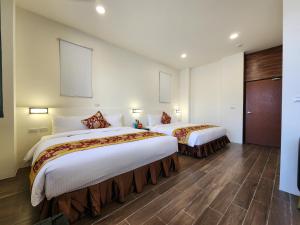um quarto de hotel com duas camas num quarto em Penghu Dayou View B&B em Magong