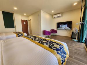 a hotel room with two beds and a tv at Penghu Dayou View B&B in Magong