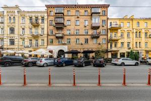 un parking avec des voitures garées devant un bâtiment dans l'établissement 2к квартира на Шота Руставелі, Бессарабка, à Kiev