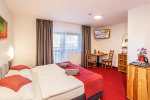 ein Hotelzimmer mit 2 Betten und einem Tisch in der Unterkunft Wellness & Restaurant U Fandy in Lhotka