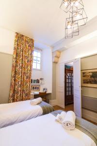 two beds in a room with a window at Coté Remparts in Amboise