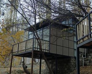 una casa con una scala accanto ad un albero di Zihin with Forest view - Cloud Nine And a Half a Baltit