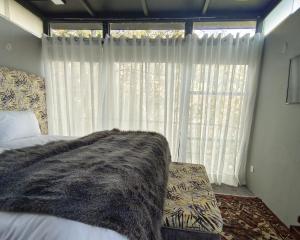 una camera con un letto e una grande finestra di Zihin with Forest view - Cloud Nine And a Half a Baltit
