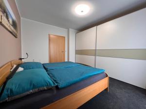 ein Schlafzimmer mit einem Bett mit blauen Kissen in der Unterkunft Schönes Haus inmitten der schönen Natur in Trofaiach