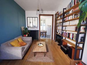 uma sala de estar com um sofá e uma mesa de centro em Charmant T2 avec jardin commun em Saint-Fons