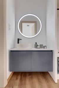 a bathroom with a sink and a mirror at Marion Suite in Ermoupoli