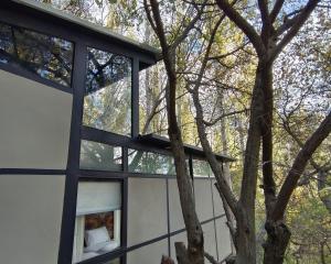 una casa con una ventana y un árbol en Kalp with Forest View- Cloud Nine and a Half Hunza, en Hunza