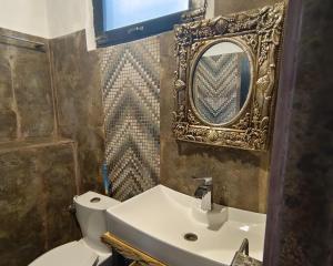 een badkamer met een wastafel, een spiegel en een toilet bij 2 Bed Chalet - Yasam Cloud Nine And a Half Hunza in Baltit