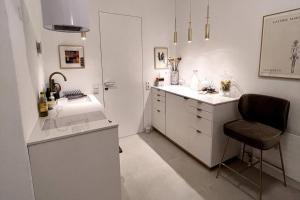 a white kitchen with a chair and a counter at Exclusive apartement in historic center in Linz