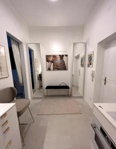 Habitación blanca con un pasillo con pinturas en las paredes. en Exclusive apartement in historic center en Linz